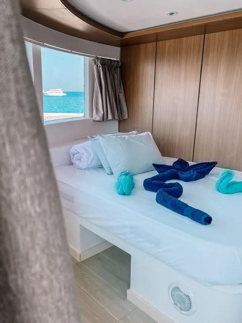 Cabin with a window, a bed and folded towels