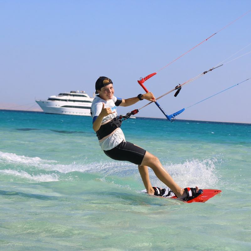 Jája kiting in a lagoon, the safari yacht behind her